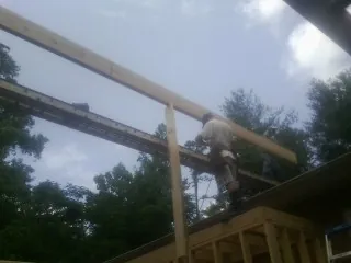 Carpenter setting a ridge beam over a new addition frame — Ice Dam Removal by Roofing Brothers in Onalaska