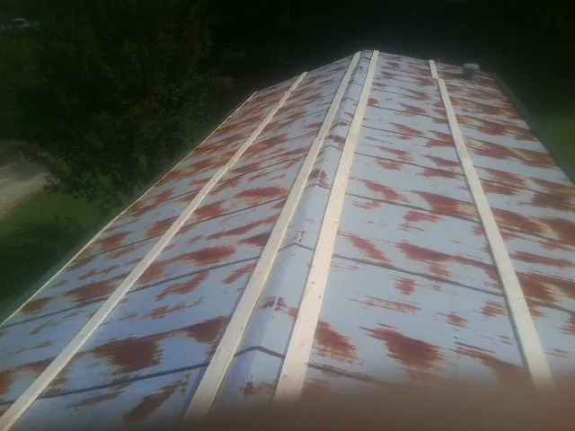 Rusted metal roof panels with new wood purlins before replacement — Storm Damage Roof Repair in Onalaska by Roofing Brothers